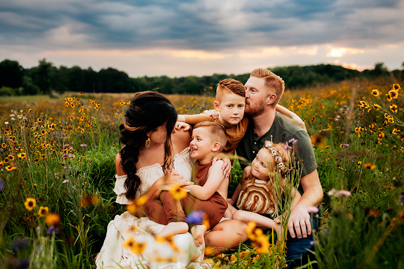Family Photographer, Family of 5 cuddle up together in wildflowers